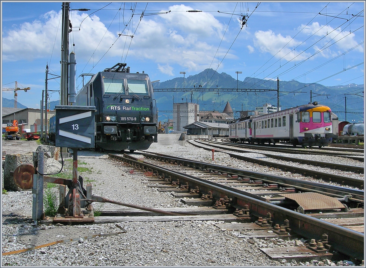 Die RTS Re 185 570-9 in Bulle, im Hintergrund verlässt ein (ex MThB) Pendelzug den Bahnhof Richtung Romont.
19. Juni 2017