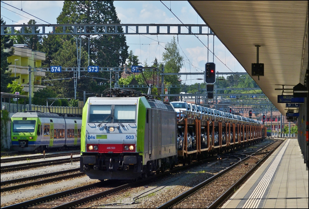 - BLS Farben mit einem Tupfer Rot - Die BLS Cargo 486 503 durchfhrt mit einem Autozug den Bahnhof von Spiez, whrend sich hinten der BLS NINA N 12 versteckt. 28.05.2012 (Hans)