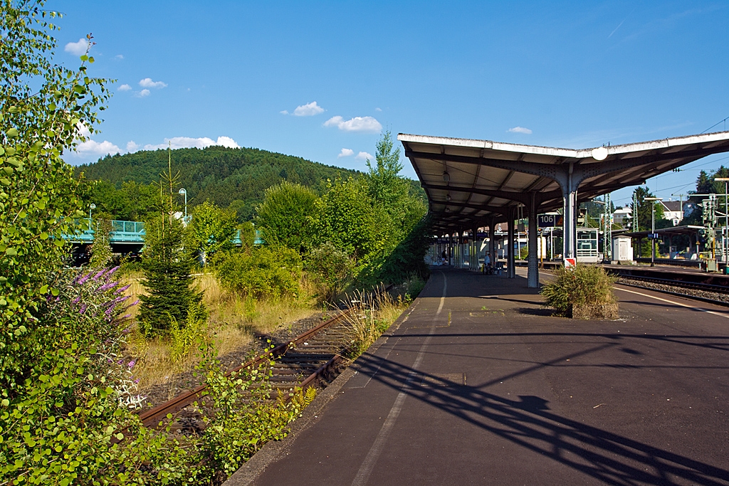 Diese Bild wird es bald so nicht mehr geben - Der Bahnhof Betzdorf/Sieg am 22.07.2013. 
Blick vom Bahnsteig 106/107 in Richtung Osten. Im Zuge von dem Dieselnetz Eifel-Westerwald-Sieg wird bald das Gleis 107 wieder reaktiviert, dann werden die Bumchen und Strucher wohl wieder weichen msse.

Betzdorf/Sieg ist ein Keilbahnhof an der KBS 460 (Siegstrecke), aus dieser Blickrichtung zweit nach rechts die KBS 462 (Hellertalbahn) ab, von der bei Alsdorf wiederum die KBS 463 (Daadetalbahn) abzweigt.

Als groe Vernderung sind ab August 2015:
• Verlngerung der RB 28 (z.Z. Limburg/Lahn – Altenkirchen/Ww – Au/Sieg) ber Betzdorf hinaus bis nach Siegen und bei einzelnen Fahrten nach/von    Kreuztal.
• Verlngerung der RB 93  Rothaarbahn  (z.Z. Bad Berleburg - Kreuztal – Siegen), ber Siegen hinaus bis nach Betzdorf.
• Durch diese beiden Manahmen Schaffung eines 30-Minuten-Taktes im RB-Angebot zwischen Betzdorf und Siegen an Werktagen.
• Verbesserte Anschlussverbindungen der RB 96  Hellertalbahn  Betzdorf – Herdorf – Haiger – Dillenburg  in Betzdorf an den RE 9 „Rhein-Sieg-Express“ und in Dillenburg an den Hessen-Express.
• Verbesserte Anbindung der Gemeinde Burbach an der KBS 462 (Hellertalbahn) durch die RB 96  Hellertalbahn .
• Verbesserte Reisekette aus dem Westerwald nach Kln mit Anschluss in Au (Sieg) an den RE 9.
• Den Zuschlag fr diese Los 2 von dem Dieselnetz EWS hat die HLB Hessische Landesbahn bekommen, hierfr werden mit der Betriebsaufnahme modernisierte Dieseltriebzge (TALENT / LINT bzw. LINT / GTW) und auch einige neue Dieseltriebwagen (LINT) zum Einsatz kommen.

Ich bin darauf gespannt, und freue mich erst mal darauf. Was mich am meisten freut ist die Tatsache, dass der NPV auf der Schiene hier wohl wieder etwas ausgebaut wird. 

Wer Triebwagen mag fr den wird Betzdorf/Sieg wohl wieder dann ein Eldorado werden.