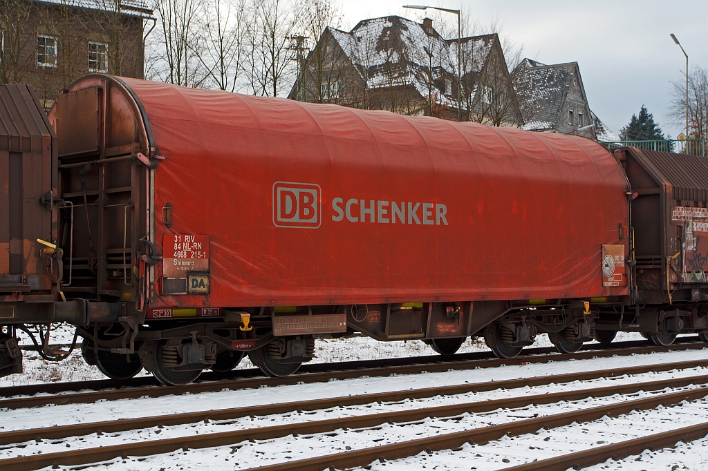 Drehgestellflachwagen mit vier Radstzen, verschiebbarem Planenverdeck und Lademulden fr Coiltransporte (Schiebeplanenwagen) der Gattung Shimmns  (4668 215-1) der DB Schnker Rail Niederlade abgestellt am 19.01.2013 in Herdorf auf der Gleisanlage der Kreisbahn Siegen-Wittgenstein (KSW). 