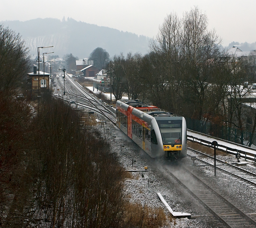 Nachschu: Stadler GTW 2/6 der Hellertalbahn kommt am 09.02.2012, bei ganz leichtem Schneefall, von Neunkirchen und fhrt gleich in den Bahnhof Herdorf ein. Danach fhrt er weiter in Richtung Betzdorf/Sieg, hier besteht dann Anschlu an den RE 9 (Rhein-Sieg-Express). Links das Stellwerk Herdorf Ost (Ho). ganz hinten links das Stellwerk Herdorf Fahrdienstleiter (Hf). Hinten rechts der Gleise der Bahnhof, davor der ehem. Gterbahnhof.