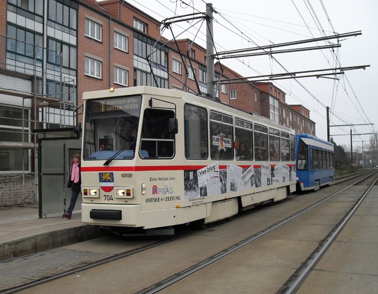 Tatra-Straenbahn vom Typ T6A2 mit Bildern von Zeitungsausschnitten ber den Mauerfall fhrt als Linie 1 von Hafenallee,Rostock Richtung Rgener St.,Rostock Aufgenommen am 10.03.10 in der Haltestelle Heinrich-Schtz-Strae,Rostock 