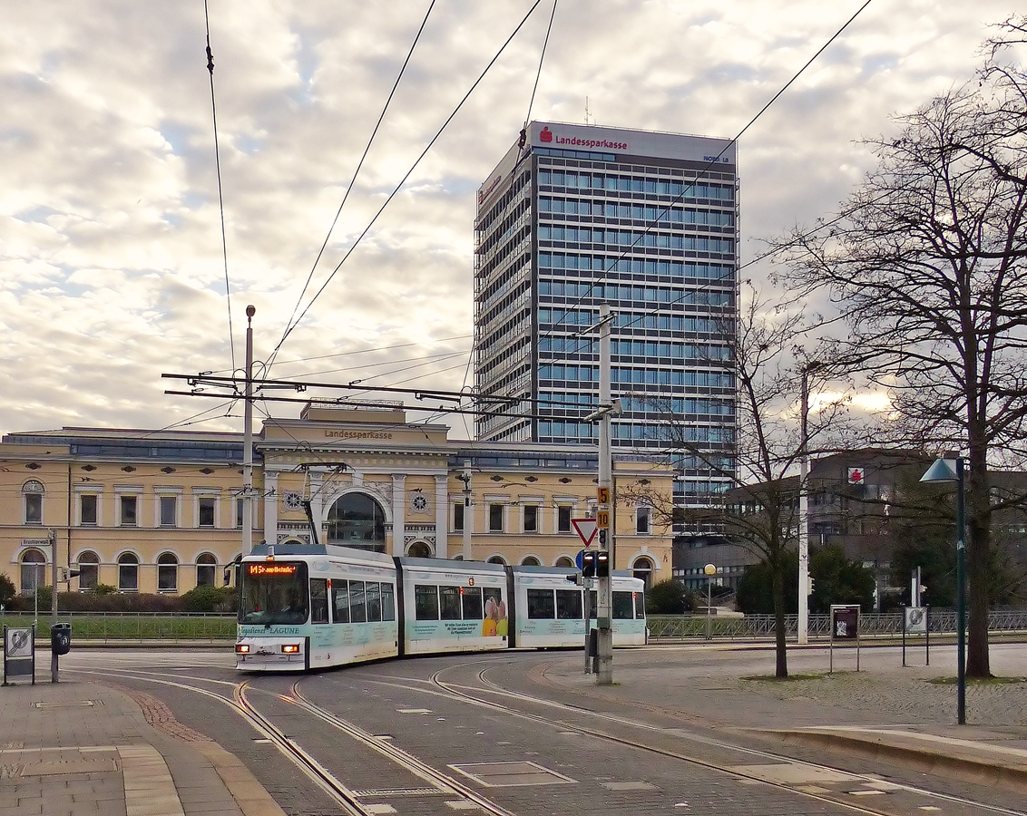 . Am alten Braunschweiger Bahnhof - Der GT6S mit der Nummer 9551 (Bj 1995) der Braunschweiger Stra�enbahn f�hrt am 03.01.2015 auf der Linie M 5 Broitzem - Hauptbahnhof und biegt vom Kalenwall auf den Friedrich-Wilhelm-Platz ein. (Jeanny)

Bei dem Geb�ude im Hintergrund handelt es sich um den ehemaligen innerst�dtischen Braunschweiger Bahnhof, einen Kopfbahnhof von 1845, dessen denkmalgesch�tztes Hauptgeb�ude heute als Hauptsitz der Braunschweigischen Landessparkasse dient.

Der einstige Sackbahnhof war ein Ottmer-Bau im gotischen Stil, wurde jedoch in den Jahren 1843/45 im sp�tklassizistischen Stil neu aufgebaut. Dieser Bau wurde durch Bombardierung 1944 gr��tenteils zerst�rt und 1960 durch einen neuen Durchgangsbahnhof au�erhalb der Innenstadt ersetzt. Vom alten Bahnhof ist der Kopfbau erhalten, dessen Fassade von einem Triumphbogenmotiv beherrscht wird. 
