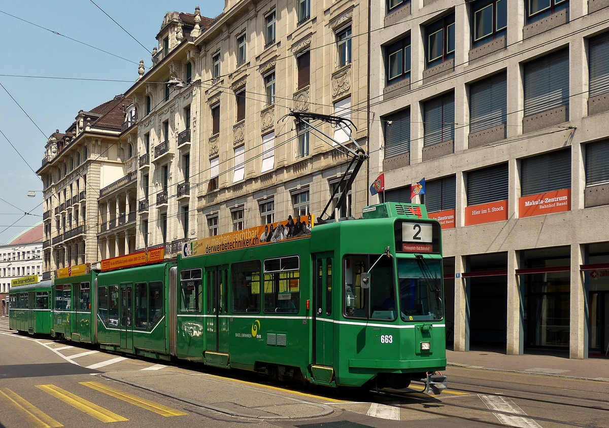 . Vor dem Bahnhof Basel SBB konnte ich am 07.06.2015 die BVB Tram Be 4/6 S N 663 ablichten, als sie auf der Linie 2 durch die Centralbahnstrasse fuhr. Wegen des Pokalspiels Basel - Sion, waren alle Basler Straenbahnen mit den Flaggen des FC Basel geschmckt. (Hans)


Bei diesem Fahrzeugtyp handelt es sich um die ursprnglichen Be 4/6, welche 1997-1999 mit niederflurigen Mittelteilen (sogenannten Snften) erweitert wurden. Sie wurden 1990-1991 von Schindler in der Anzahl von 28 Stck gebaut und werden als Guggummere bezeichnet.
