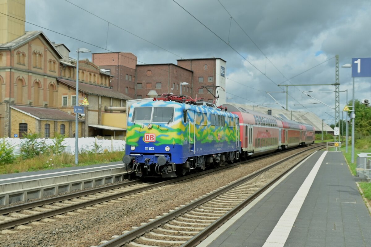 111 074 alias Hilde im Touristikdesign leistet auf dem RE8 Ersatzdienst und ist hier in Kochendorf vor Salzbergwerk abgelichtet am 29.7.23