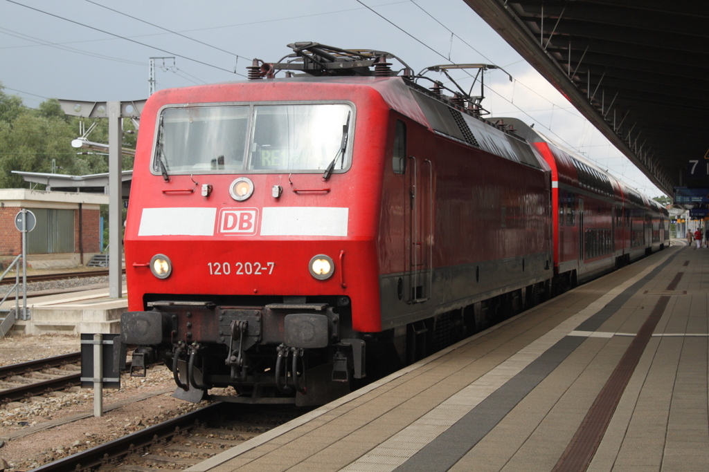 120 202-7 mit RE4308 von Rostock Hbf nach Hamburg Hbf bei der Ausfahrt in Rostock im Hintergrund kam dann ein heftiger Regenschauer.29.07.2016