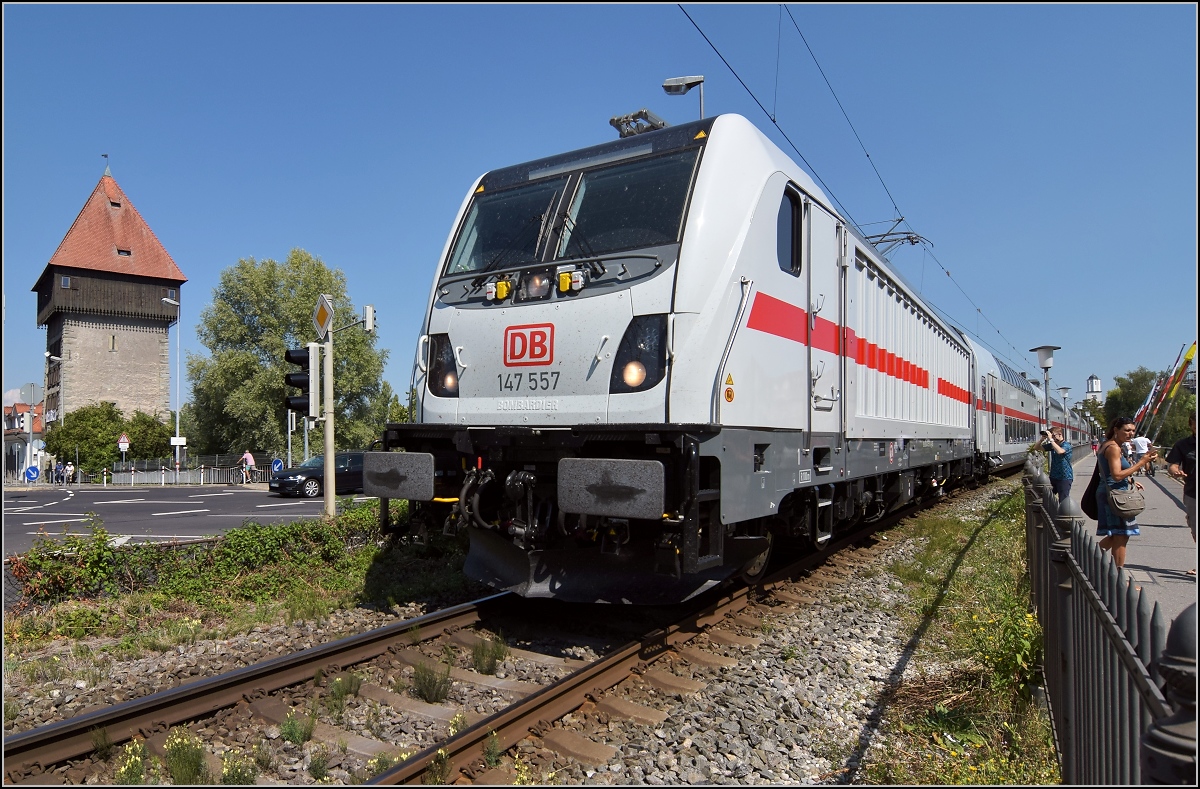 147 557 mit dem schweizgängigen Dostopark auf dem alternativen Streckenast auf der Rheinbrücke in Konstanz, dahinter der Rheintorturm. So betrachtet macht sie ihrem Spitznamen Spundwand alle Ehre. August 2018.