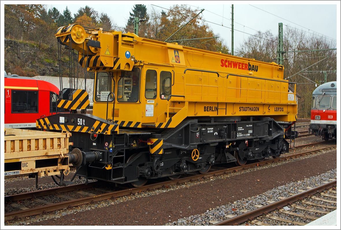 50t-KIROW-Schienenkran EDK 300/5  der Schweerbau, Schweres Nebenfahrzeug Nr. 97 82 31 501 17-9 (ex 60 80 092 3 747-0), abgestellt am 24.11.2013 in Au/Sieg.
Der Kran wurde 1984 vom VEB Schwermaschinenbau  S.M.KIROW   in Leipzig unter der Fabriknummer 34 gebaut.

Technische Daten
Eigengewicht: 100 t
Länge über Puffer: 12.510 mm
Achsanzahl: 6 (in zwei Drehgestellen)
Drehzapfenabstand: 5.690 mm
Achsabstand in den Einzeldrehgestellen: 3.100 mm (2x 1.550 mm)
Fahrgeschwindigkeit im Zugverband: 100 km/h
Fahrgeschwindigkeit mit Eigenantrieb: 6 km/h
Zugelassen als Schwerwagen für Streckenklasse: D4 
kleinster befahrbarer Radius: 120 m