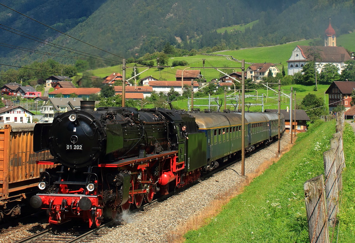 Am 11.09.2016 fährt die 01 202 mit einem Sonderzug bei Silenen die Gotthard-Nordrampe hoch. Der mit vier Re 4/4 II bespannte talwärts fahrende Güterzug (siehe die Stromabnehmer hinter dem Sonderzug) hätte ruhig etwas später kommen können...