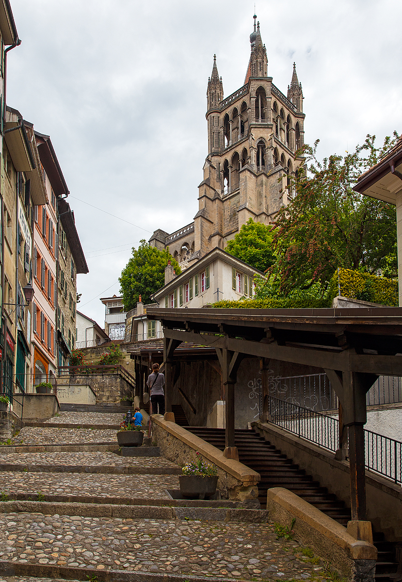 
An der Markttreppe (Escaliers du Marche) eine überdachte Holztreppe aus dem Mittelalter 13 Jahrhundert in der Altstadt von Lausanne am 21.05.2018. Oben die Kathedrale Notre-Dame. 

Die überdachte Escaliers du Marché, die von der Place de la Palud zur Kathedrale führt, ist zweifellos einer der malerischsten Orte des Stadtzentrums. Diese Treppe bestand bereits im 13. Jahrhundert und diente als Verbindungsweg zwischen den beiden Märkten der mittelalterlichen Stadt. Entlang der Treppe stehen Wohnhäuser aus dem 16. Jahrhundert.