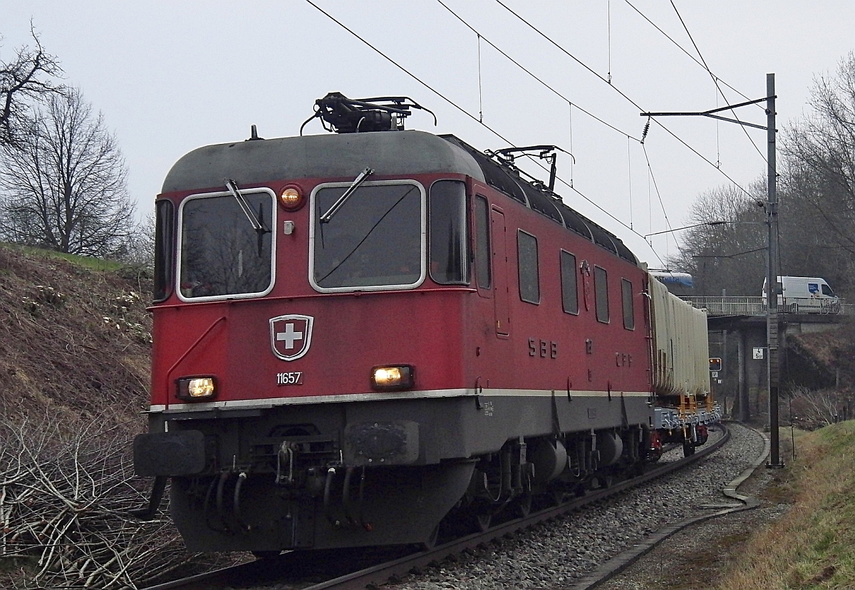 Auch wenn es bergauf geht, benötigt die von Romanshorn kommende Re 6/6 11657 'ESTAVAYER-LE-LAC' nur einen geringen Teil ihrer verfügbaren Leistung, um den einen Wagen Richtung St. Gallen zu ziehen (Olmishausen, 01.03.2011).