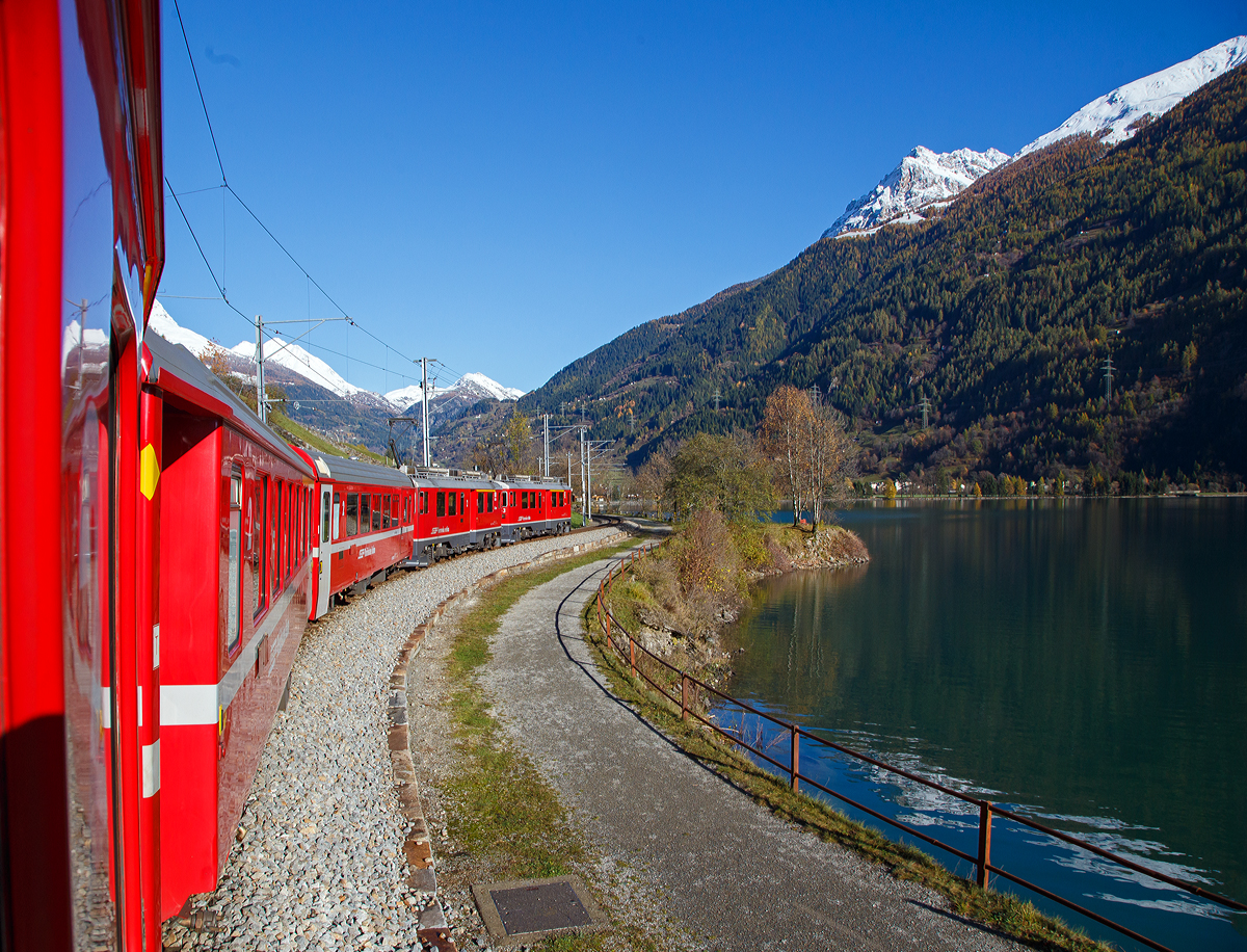 
Auf der Rückfahrt, bei und bestem Kaiserwetter....
Geführt von den beiden RhB ABe 4/4 III Triebwagen, Nr. 53  Tirano  und Nr. 54  Hakone , fährt unser RhB Regionalzug von Tirano nach St. Moritz, am Lago di Poschiavo entlang.