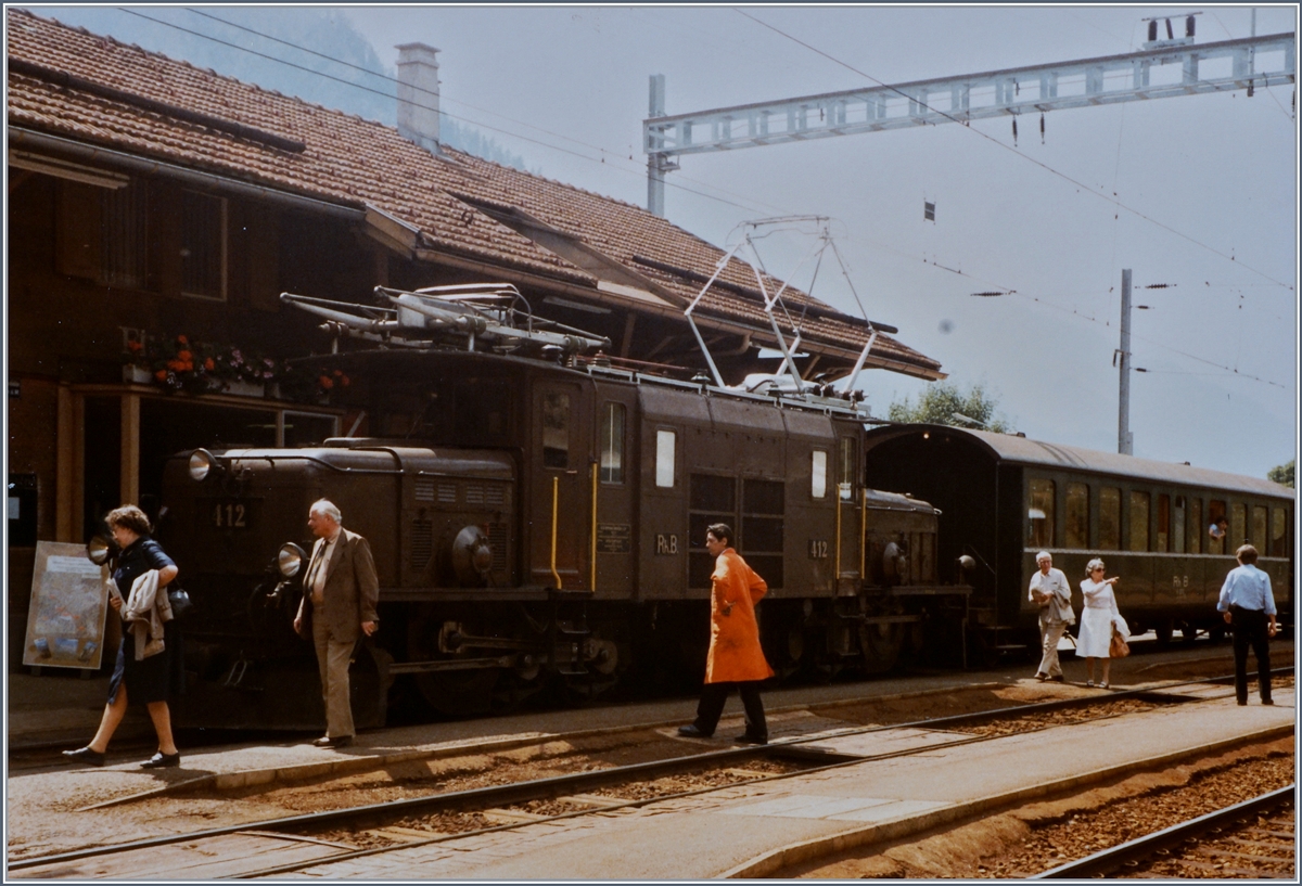 Bahnhofszene in Filisur mir der Ge 6/6 I 412, einigen Reiseden, Zug- und Stationspersonal. 
20. August 1984