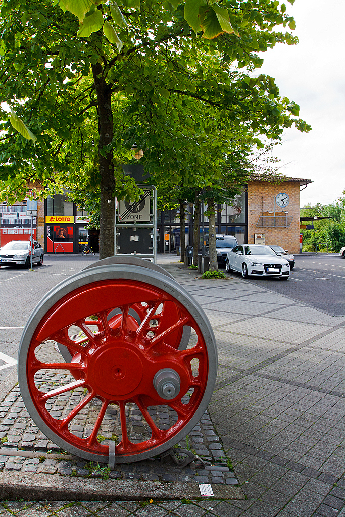 Blick auf das Empfangsgebude vom Bahnhof Betzdorf/Sieg (am 13.07.2014). Im Vordergrund eine Treibachse einer Dampflokomotive der Baureihe 044 (Baujahr 1942, Ausmusterung 1973). Bis in die 1970er-Jahre waren im AW Betzdorf auch  Jumbo´s  (Dampflok der BR 044) beheimatetet.