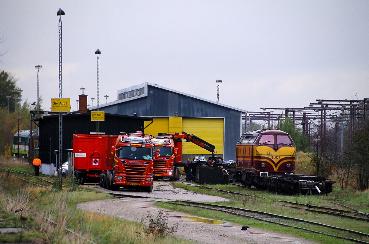 CFL 1807 steht mit einer Sammlung ausgedienter oder noch verwendeter Drehgestelle vor der Contec Werkstatt in Padborg, dahinter wird die DSB MT 167 bzw deren Reste  transportfertig  gemacht. 29.10.2013