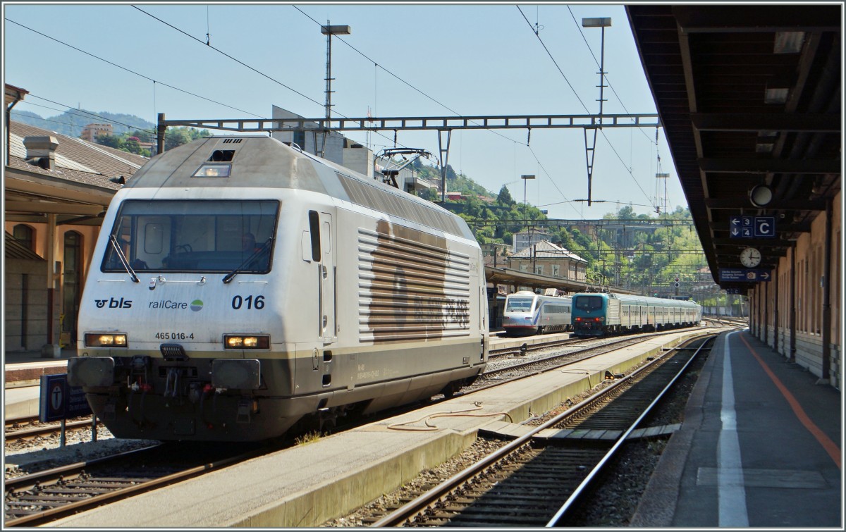 Chiasso, oder Kilometer 206 der Gotthardbahn. Hier im Grenzbahnhof werden die Züge von der italienischen Bahn zur Weiterfahrt Richtung Süden übernommen. 
Im Bild die BLS Re 465 016-4  Black Pearl  sowie im Hintergrund ein SBB ETR 470 und ein FS Regionalzug.
5. Mai 2014