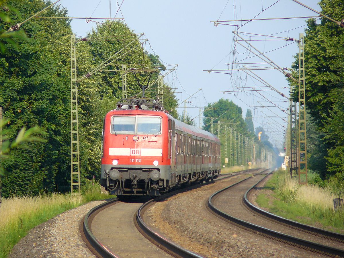 DB loc 111 113-7 mit Silberlingen. Bahnbergang Schwarzer Weg, Vrasselt bei Emmerich am Rhein 03-07-2015.

DB loc 111 113-7  met Silberling rijtuigen nadert de overweg Schwarzer Weg, Vrasselt bij Emmerich, Duitsland 03-07-2015.