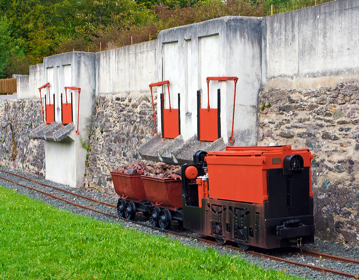 
Denkmal Grubenlok, eine 600mm Siemens-Schuckert-Werke (SSW) Gruben-Akkulok vom Typ GA-Bo-5/17-1, am 20.09.2014 in Weilburg-Ahausen, mit zwei angehängten Loren.
In der Nähe der Lahnbrücke ist die ehem. Verladestelle der ehemalige Erzgrube  Allerheiligen  als schönes Industriedenkmal erhalten worden und diese sowie eine weitere Denkmallok wurden davor platziert. 

Die Akku-Lok wurde 1968 von SSW unter der Fabriknummer 6306 (laut Siemens-LV 6303) gebaut und an das Bergwerk Ewald in Herten (Ewald Kohle AG, ab 1969 RAG) geliefert. Später ging sie zum RAG Maschinen-Übungszentrum in Recklinghausen als Nr. 3, ab 1995 als Museumslok zur Arbeitsgemeinschaft Muttenthalbahn e.V. in Witten/Ruhr  als 52  HEIDI , bis sie 2007 vom Heimatverein Ahausen als Denkmal erworben werden konnte.

Technische Daten:
Typ: SSW GA-Bo-5/17-1
Bauart: Bo – akku
Spurweite: 600 mm
Batterie: Hagen Batterie, 36 Zellen, 500 AH 