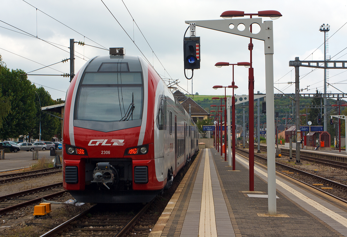 Der CFL 2306 ein dreiteiliger Elektrischer Doppelstocktriebzug Stadler KISS, steht am 14.09.2014 auf Gleis 9 im Bahnhof Wasserbillig als RB nach Luxemburg bereit. Der KISS setz sich zusammen aus den Wagen 94 82 0023 061-3 L-CFL, 94 82 0023 062-1 L-CFL und L-CFL 94 82 0023 063-9 L-CFL.

Diese ersten 8 KISS der 1.Serie (2301 – 2308) wurden 2013 von der Stadler Pankow GmbH (Berlin) gebaut. Weitere 13 weitere Stadler KISS der 2.Serie (2309 – 2321) wurden 2017 (11 Stck) und 2020 (2 Stck) gebaut, sie besitzen mehr Sitzpltze in der 1. Klasse.

Nach Ankndigung der DB Fernverkehr AG, drei der fnf bestehenden IC-Verbindungen zwischen Luxemburg und Koblenz zu streichen, haben das Ministerium fr nachhaltige Entwicklung und Infrastruktur Luxemburg, das Ministerium des Innern, fr Sport und Infrastruktur des Landes Rheinland Pfalz, die CFL, SPNV-Nord und die DB Regio AG eine Ersatzlsung ausgearbeitet.

Ab dem Fahrplanwechsel Mitte Dezember 2014 ist wie folgt vorgesehen: Eine stndliche Zugverbindung zwischen Luxemburg und Koblenz, mit Flgelung der von Saarbrcken kommenden Zge (dann FIRT 3) in Trier. Die Verbindung Luxemburgs mit dem deutschen Fernverkehrsnetz wird somit deutlich verbessert.

Die CFL (Socit Nationale Chemins de Fer Luxembourgeois) hat acht dieser dreiteiligen doppelstckigen Triebwagen bei Stadler gekauft (mit einer Option auf 31 weitere), diese wurden bei Stadler Pankow GmbH gebaut. Die Fahrzeuge sind mit ETCS ausgestattet und erreichen eine Hchstgeschwindigkeit von 160 km/h. Sie knnen unter den Stromsystemen 25 kV, 50 Hz (in Luxemburg) und 15 kV, 16,7 Hz (in Deutschland) verkehren.

Die KISS, die von der Stadler Pankow GmbH gefertigt werden, unterscheiden sich vom ursprnglichen KISS-Modell dadurch, dass sie das Lichtraumprofil G2 einhalten, um auf dem Netz der DB Netz uneingeschrnkt eingesetzt werden zu knnen. Dadurch ist der Raum im Schulterbereich des Oberstocks enger als bei den Schweizer Triebzgen. Im Gegenzug dazu war es mglich, die Einzelwagen zu verlngern und den Wagenkasten um 35 mm zu erhhen. Auch wurden die Fahrzeugkpfe neu gestaltet, um neueren Crash-Anforderungen zu gengen. Darber hinaus sitzen die Stromabnehmer auf den Mittelwagen; in den Endwagen werden nur die Drehgestelle an den Wagenbergngen angetrieben, wobei leistungsstrkere Motoren eingesetzt werden.

TECHNISCHE DATEN:
Spurweite: 1.435 mm
Achsanordnung: 2‘Bo‘ + 2‘2‘ + Bo‘2‘
Lnge ber Kupplung: 79.840 mm
Fahrzeugbreite: 2.800 mm
Fahrzeughhe: 4.630 mm
Lichtraumprofil: G2
Drehzapfenabstand: 18.550 mm
Achsabstand im Drehgestell: 2.500 mm
Triebraddurchmesser: 920 mm (neu)
Dienstgewicht: 170,1 t
Max. Leistung am Rad: 3.000 kW (4750 kW)
Dauerleistung am Rad: 2.000 kW (4 500 kW)
Anfahrzugkraft: 200 kN
Hchstgeschwindigkeit :160 km/h
Max. Beschleunigung: 0,83 m/s2 bis 80 km/h
Speisespannung: 25 kV, 50 Hz und 15 kV, 16 ⅔ Hz
Sitzpltze (Serie I): 1. Klasse 29 / 2. Klasse 262 (davon 33 Klappsitze)
Sitzpltze (Serie II): 1. Klasse 38 / 2. Klasse 254 (davon 33 Klappsitze)
Kupplung: Scharfenbergkupplung (Schaku) Typ 10
Besonderheiten: Mehrfachtraktionsfhig (bis zu 3 KISS) und mit FLIRT
