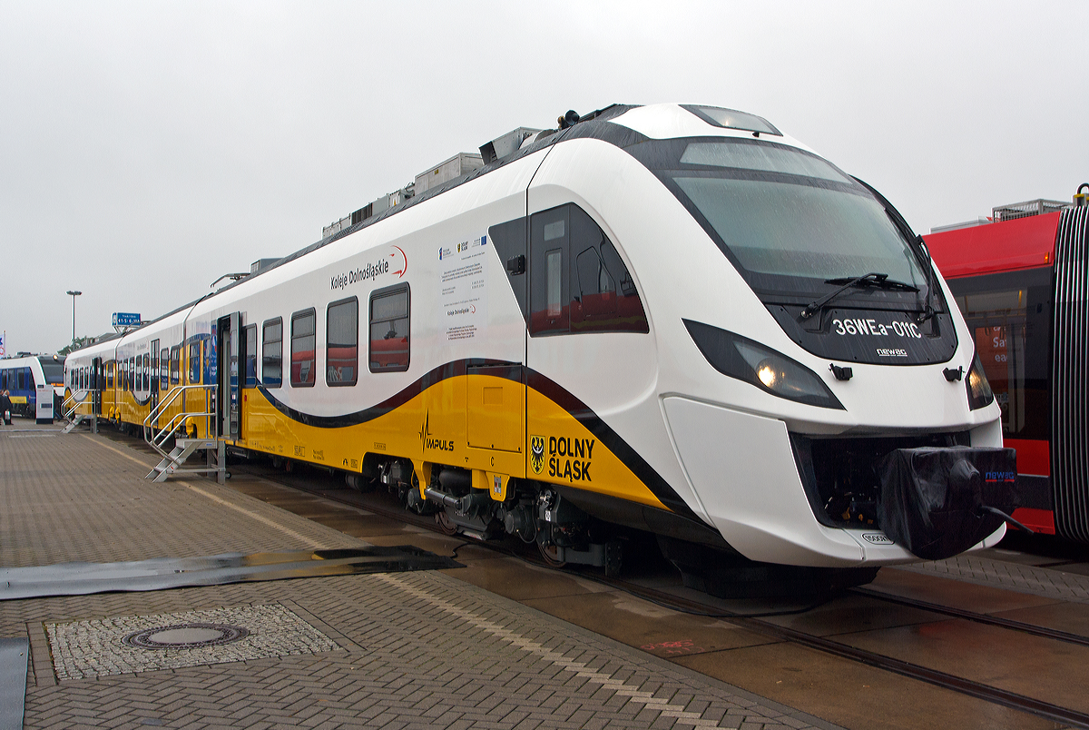 Der dreiteilige Elektrotriebwagen Newag Impuls WE36a - 011C der Koleje Dolnośląskie (deutsche �bersetzung: Niederschlesische Eisenbahn) ausgestellt auf der InnoTrans 2014 (hier am 26.09.2014).
 
Diese normalspurigen Standard-Elektrotriebz�ge der  Familie „Newag Impuls“ werden haupts�chlich f�r das polnische 3000 V-Gleichstromnetz von der Firma NEWAG Sp�łka Akcyjna gebaut. Das Sortiment besteht aus Modellen 31WE, 35WE, 36WE, 36WEa und 37WE.

Technische Daten:
Spurweite: 1.435 mm (Normalspur)
Achsanordnung: Bo’2’2’Bo’
L�nge �ber Kupplung: 58.400 mm
Fahrzeugbreite: 2.840 mm
Fahrzeugh�he: 4.150 mm
Max. Passagiere: 330
Eigengewicht: 107 t
Dienstgewicht: ca. 135 t
Triebraddurchmesser: 840 mm
Antrieb: 4 x 400 kW (=1.600 kW) Nennleistung
Motorentyp:  Asynchronmotoren
Stromsystem: 3000 V DC
Anfahrzugkraft: 185 kN
H�chstgeschwindigkeit: 160 km/h
Beschleunigung: 1,0 m/s�
