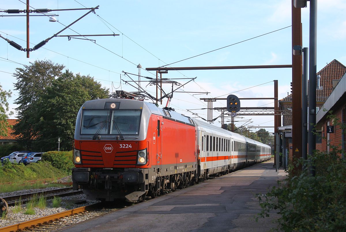 Der IC 1192 nach Kopenhagen hat sich durch den verspäteten Gegenzug IC 1197 auch eine Verspätung von 27 Minuten eingefangen, die DSB 3224 versucht, Schwung zu holen, um den IC 1192 über eine 150 m lange stromlose Trennstelle zu bringen, Pattburg 15.08.2023