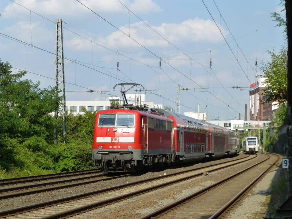 Der letzte verbliebene Nahverkehrszug mit Wagen in Wuppertal ist der RE 4, am 31.8.16 schiebt 111 150 die Fahrgäste Richtung Osten. Im Hintergrund kommt schon die S7 aus Solingen angerollt.