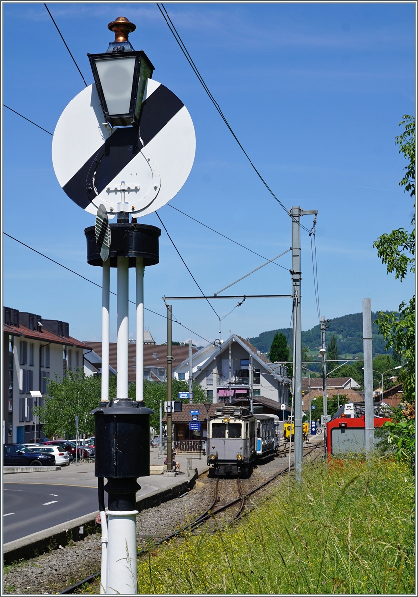 Der LLB (Leuk - Leukerbad Bahn 1915 - 1967) Triebwagen mit der phantasievollen Bezeichnung ABFe 2/4 N° 10 wartet im Blonay seinem Zug nach Chamby auf die Abfahrt, das Ausfahtsignal, eine die Hippsche Wendescheibe, zeigt dem Zug jedoch noch nicht Freie Fahrt.

21. Mai 2022