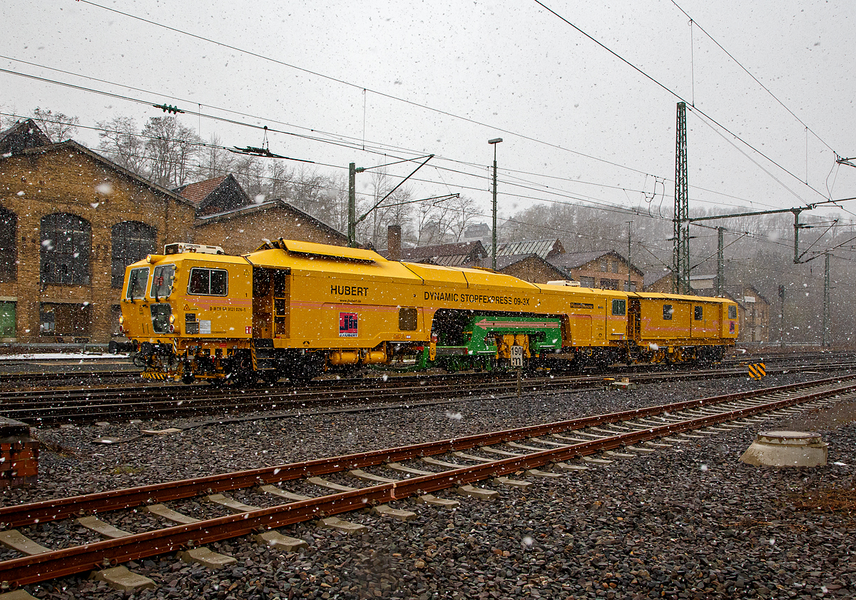 Der n�chste Schneeschauer ist da und....
Der Plasser & Theurer Dynamic Stopfexpress 09-3X, Schweres Nebenfahrzeug Nr. 99 80 9121 026-5 D-JH, ex 97 40 71 507 17-1, eine Dreischwellenstopfmaschine Joseph Hubert GmbH & Co. KG, f�hrt am 06.04.2021 bei starkem Schneefall durch Betzdorf/Sieg in Richtung Siegen.


Der Dynamic Stopfexpress 09-3X wurde 2003 von Plasser & Theurer in Linz (A) unter der Maschinen-Nr. 3097 gebaut.  Die Dynamic 09-3X sind kontinuierlich arbeitende Nivellier-, Hebe-, Richt- und Drei-Schwellen-Stopfmaschinen mit integrierter dynamischer Gleisstabilisation. Sie erm�glichen das Stopfen von drei Schwellen in einem Arbeitsgang. Dadurch wird eine hohe Arbeitsgeschwindigkeit erzielt. Diese Maschinen sind jedoch f�r den Bereich von Weichen geeignet. Bei der Stopfung wird der Schotter unter der Schwelle verdichtet, wodurch ein stabiles Schwellenauflager entsteht.


TECHNISCHE DATEN:
Spurweite: 1.435 mm
L�nge �ber Puffer: 33.540 mm
Gesamtgewicht: 126 t
H�chstgeschwindigkeit eigen/gezogen:100km/h 
Motorleistung: 550 kW
