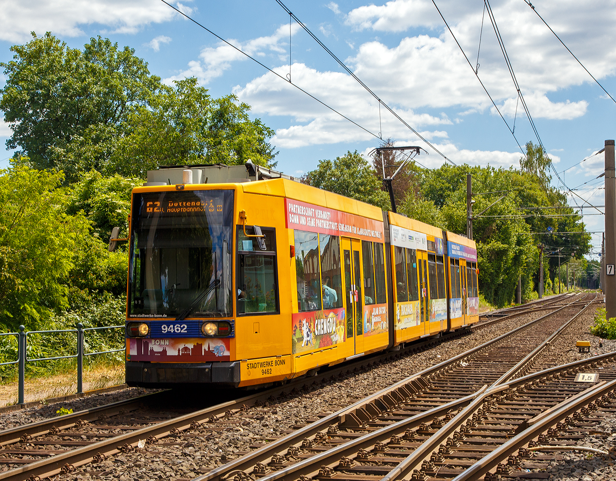 
Der Triebwagen 9462 der SWB (Stadtwerke Bonn Verkehrs GmbH) erreicht am 30.05.2020, als Linie 62 nach Dottendorf, bald die Haltestelle Beuel Bahnhof. Der Zweirichtungs- Niederflur-Gelenktriebwagen ist ein 1993 gebauter DUEWAG-Niederflurwagen vom Typ MGT6D der Bauart NGT6 (6xGlNfTwZR), von der SWB als Typ R1.1 bezeichnet.

Da sich die Strecken nach Dottendorf und Graurheindorf (Auerberg) schlecht für eine Umstellung auf Stadtbahnbetrieb eignen, verfolgten die SWB die Entwicklung der Niederflurtechnik mit großem Interesse. Neben Düsseldorf und Mannheim erhielt man 1991 einen der Prototypen der vom VÖV konzipierten Niederflur-Stadtbahn 2000. Insbesondere die ehrgeizige Technik mit selbstlenkenden Einzelrad-Einzelfahrwerken (EEF) konnte nicht überzeugen. 

Stattdessen wurden 1994 insgesamt 24 Siemens/Düwag R1.1 (NGT6)-Niederflurstraßenbahnwagen mit konventionellen Antriebsdrehgestellen und Einachslaufwerken im Mittelteil beschafft, die seither alle Straßenbahnlinien bedienen. Die Straßenbahnwagen wurden wie bei den meisten Stadtbahnwagen mit neuen orangen LED-Anzeigetafeln und Kundeninformationssystemen ausgestattet, so dass nun auch im Fahrzeuginneren die Ankunft an den nächsten Stationen sowie an der Endhaltestelle ablesbar ist. 

Bis heute haben die R1.1 Triebwagen keine Nachfolger. Da sie sich nach reichlich 20 Jahren Einsatzzeit aber bereits in einem verbrauchten Zustand befinden der die Triebwagen zudem sehr wartungsintensiv macht, sollte in nicht allzu ferner Zukunft mit Ersatz für diese Serie gerechnet werden.

TECHNISCHE DATEN:
Spurweite: 1.435 mm
Bauart: 6xGlNfTwZR
Achsfolge: Bo'+1'1'+Bo'
Gesamtlänge: 28.570 mm 	
Wagenkastenbreite : 2.400 mm
Niederfluranteil: ca. 65 %
Sitzplätze: 72
Stehplätze: 97(4 Pers/m²)
Netzspannung: 	750 V DC Oberleitung
Leistung: 4 x 105 kW
Höchstgeschwindigkeit: 70 km/h
