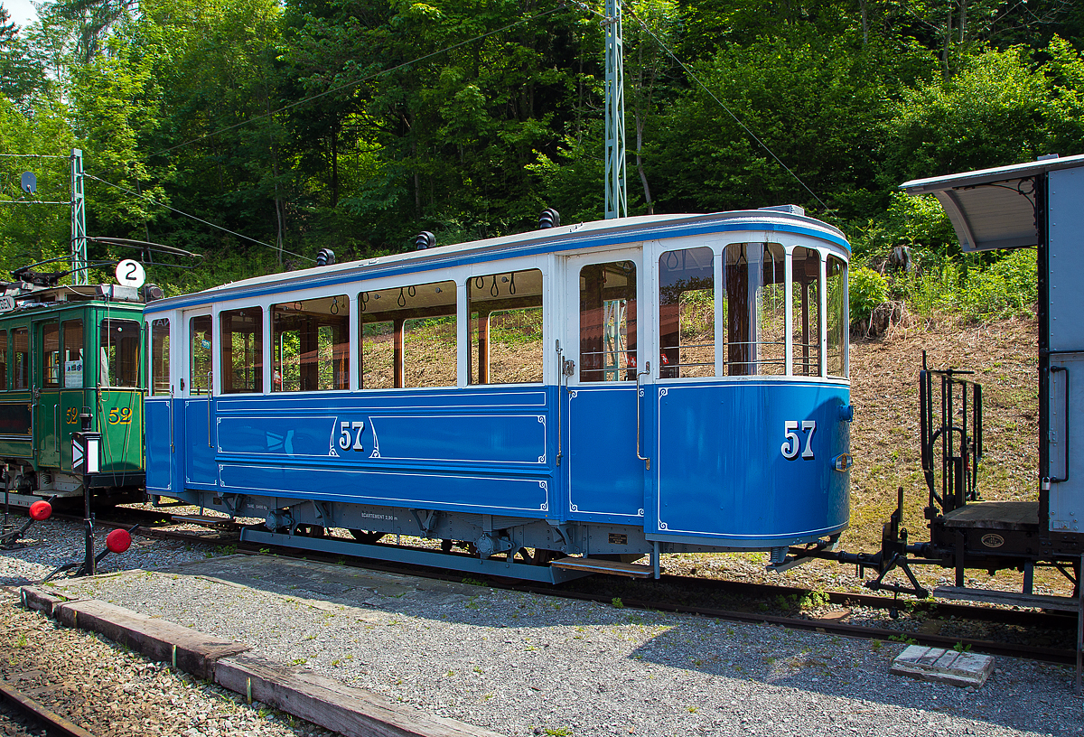 Der zweiachsige Straßenbahn-Beiwagen C 57, ex VMCV C 57, ex BVB C 57 am 19.05.2018 auf dem Museums-Areal der Museumsbahn Blonay-Chamby. 

Der Beiwagen wurde 1930 von SIG (Schweizerische Industrie-Gesellschaft) in Neuhausen am Rheinfall für die Straßenbahn VMCV (Transports publics Vevey–Montreux–Chillon–Villeneuve) gebaut. Die Straßenbahn wurde bis 1958 schrittweise komplett eingestellt und durch den Trolleybus Vevey–Villeneuve ersetzt. So ging der Wagen 1958 an die BVG (Bex-Villars-Bretaye-Bahn, französisch Chemin de fer Bex–Villars–Bretaye, heute TPC), 1970 wurde der Wagen an die Blonay-Chamby verkauft, wo er aber nur ausgestellt war. Im Januar 1999 ging er als Leihgabe an die BVB zurück, wo er vom Förderverein repariert und restauriert wurde. Im Juni 2011 ging der Wagen wieder an die Blonay-Chamby zurück. Seit 2013 ist er nun wieder in den ursprünglichen VMCV C2 57 um bezeichnet. Nur fährt er nicht mehr an der Waadtländer Riviera, sondern etwas oberhalb von ihr.

TECHNISCHE DATEN:
Spurweite: 1.000 mm (Meterspur)
Achsanzahl: 2
Länge über Kupplung: 8.830 mm
Länge Wagenkasten: 8.130 mm
Breite: 2.000 mm
Achsabstand: 2.900 mm
Eigengewicht: 5.400 kg
Sitzplätze: 18
Stehplätze: 31

Geschichte der VMCV:
Die erste elektrische Straßenbahn der Schweiz wurde im April 1888 zwischen Vevey, Montreux und Chillon (VMC) in Betrieb genommen, sie war so auch die erste elektrische Bahn der Schweiz überhaupt.

Diese Linie war eine Attraktion für die vielen ausländischen Gäste, die in den Luxushotels übernachten, die Ende des 19. Jahrhunderts an diesem privilegierten Teil der Waadtländer Riviera eingerichtet wurden. Die 1881 in Paris stattfindende Great Electricity Exhibition überzeugte die Projektträger von Vevey, diese revolutionäre Traktionsmethode anstelle der ursprünglich geplanten Druckluft anzuwenden. 

Die Fahrleitung war zweipolig und bestand aus einem aufgehängten, unten geschlitzten Kupferrohr in dem ein Kontaktschlitten über eine Leine mit Stromkabel vom Tramwagen mitgezogen wurde (System SIEMENS). Die Schienen wurden nicht als Rückleiter benutzt. Die ersten Motorwagen hatten sogar ein begehbares Dach mit Bänken, wo auch in den ersten Betriebsjahren ein Mitarbeiter saß, das komplexe und heikle System der Stromzuführung überwachte und führte.

Die Konzession für die Verlängerung Chillon – Byron – Villeneuve ging dann an die CBV welche den Betrieb 1903 eröffnete. Die Betriebsführung hatte die VMC. Im Jahr 1913 fusionierten die beiden Gesellschaften zur VMCV und erneuerten die Straßenbahn komplett. Neue Fahrleitung im nun gebräuchlichen System, vollständig neues Rollmaterial und größtenteils erneuertes Gleis.

Das Tram wurde immer sehr gut frequentiert, doch auch hier brachte der Straßenverkehr die Bahn in Bedrängnis. Als es dann darum ging das ausschließlich zweiachsige Rollmaterial meist von 1913 zu ersetzen, entschloss sich das Unternehmen auf Trolleybus umzustellen.
