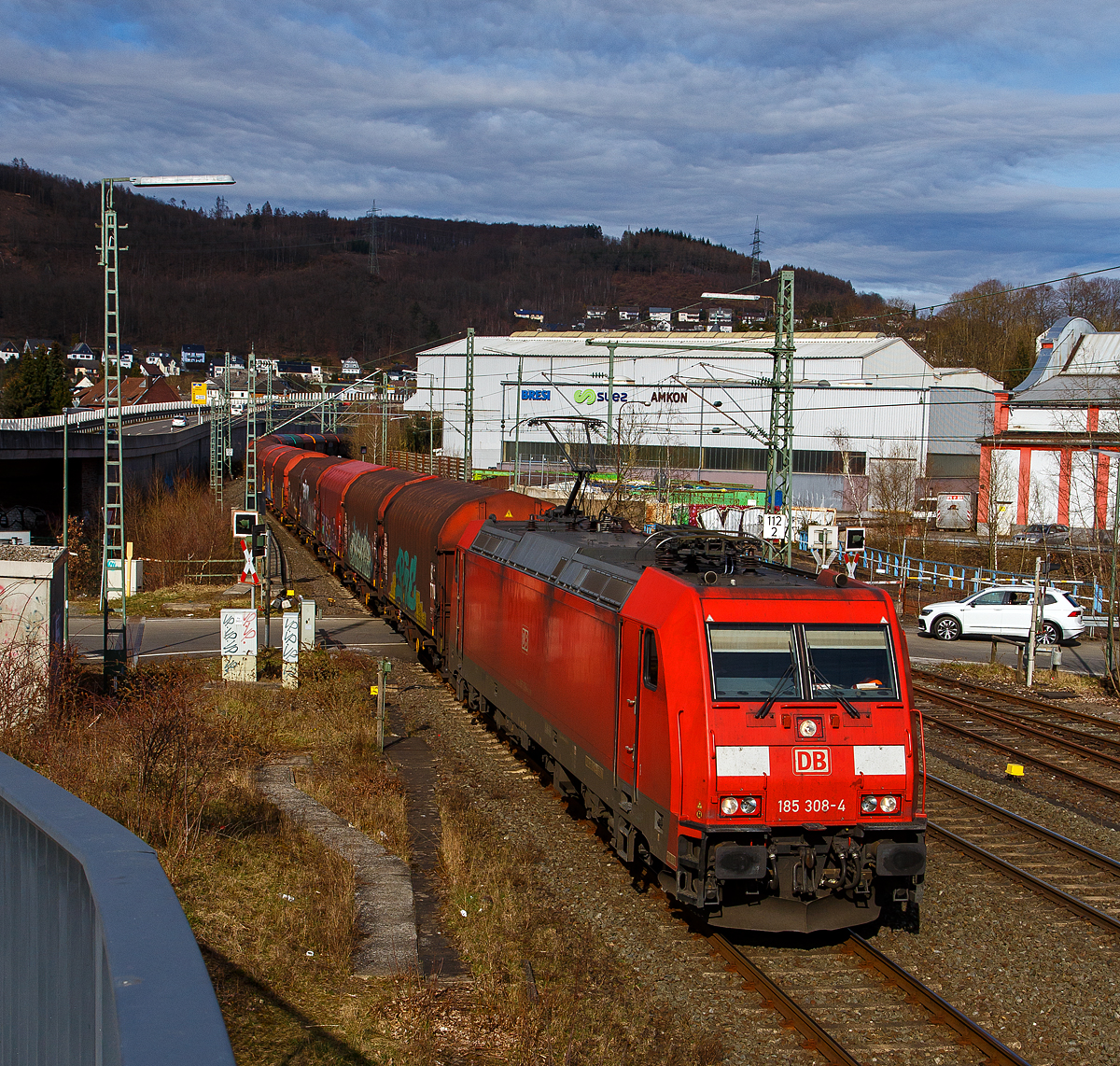 Die (91 80 6185 308-4 D-DB) der DB Cargo AG fährt am 20.03.2021, mit einem langen Coilzug, über die Siegstrecke (KBS 460) durch Niederschelden bzw. Niederschelderhütte in Richtung Köln. Hinter dem Bahnübergang befindet sich die Siegbrücke, die Sieg ist hier Bundes-Landesgrenze. So befinden sich hier im Bild die Lok und die ersten Wagen in Rheinland-Pfalz, während die anderen Wagen noch in Nordrhein-Westfalen sind. 

Die TRAXX F140 AC2 wurde 2007 von Bombardier in Kassel unter der Fabriknummer 34176 gebaut.
