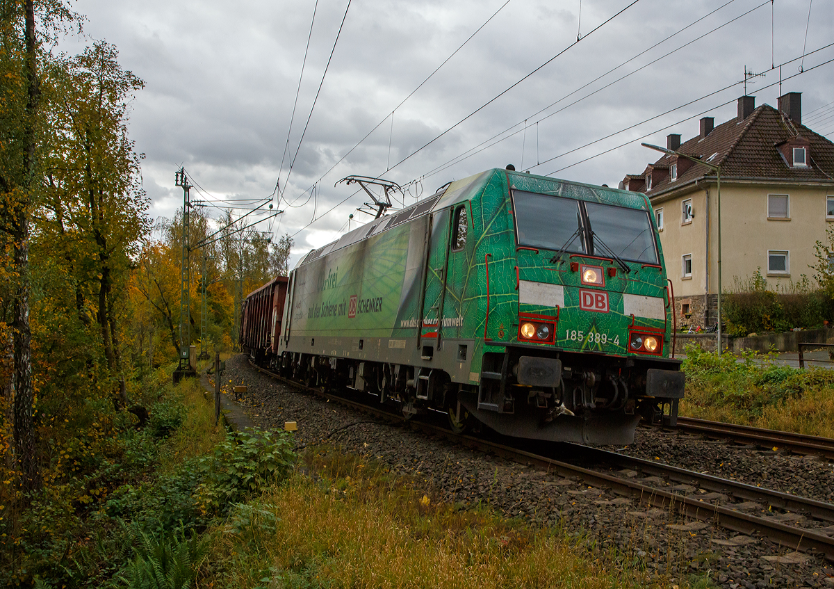 Die grüne DB Cargo 185 389-4 (91 80 6185 389-4 D-DB), mit Werbung „DB Schenker/Audi Logistik Co2-frei“, fährt am 22.10.2021 mit einem offenen Güterzug (Wagen der Gattung Eaos-x) durch Kirchen (Sieg) in Richtung Siegen. Hinweis: Ich stehe beim BÜ km 121,192.

Die TRAXX F140 AC2 wurde 2009 von Bombardier in Kassel unter der Fabriknummer 34693 gebaut. Sie hat die Zulassungen für Deutschland und Österreich.
