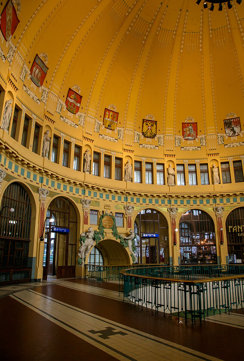 Die historische ehemalige Schalterhalle im Jugendstil vom Hauptbahnhof Prag (Praha hlavní nádraží) am 23.11.2022.

Der Bahnhof wurde im Jahr 1871 von der k.k. priv. Kaiser Franz-Josephs-Bahn (KFJB) als Endpunkt ihrer Strecke von Wien gebaut und hieß zunächst Prag Kaiser-Franz-Joseph-Bahnhof (tschechisch: Nádraží císaře Františka Josefa(. Das erste Gebäude wurde von den Architekten Vojtech Ignaz Ullmann und Anton Viktor Barvitius entworfen. In den Jahren 1901–1909 wurden, neben den technischen Erweiterungen, nach dem Entwurf des bedeutenden Architekten Josef Fanta das bis heute genutzte Aufnahmegebäude im Jugendstil gebaut.

Nach dem Ersten Weltkrieg wurde der Bahnhof nach dem amerikanischen Präsidenten Woodrow Wilson in Wilson-Bahnhof (Wilsonovo nádraží) umbenannt. Unter der deutschen Besatzung (1939–1945) hieß er Hlavní nádraží (Hauptbahnhof). Nach dem Zweiten Weltkrieg hieß er wieder Wilson-Bahnhof, allerdings nur bis zur nochmaligen Rückumbenennung in Hauptbahnhof 1953. 