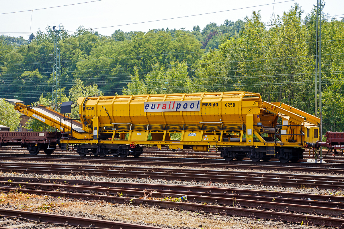 
Die Plasser & Theurer Materialfrder- und Siloeinheit MFS 40 Nr. 0250 der eurailpool GmbH,  Schweres Nebenfahrzeug Nr. 99 80 9 552 011-5 abgestellt am 04.07.2015 in Betzdorf/Sieg.

Die Materialfrder- und Siloeinheiten dienen sowohl der Materialversorgung als auch zum Abtransport der Aushubmassen ohne Benutzung des Nachbargleises. Die Beladung erfolgt mittels Radlader oder Bagger ber eine Beladestation oder direkt in die MFS. Der Abraum wird ber schwenkbare Frderbnder auf Zwischenlagerpltze oder K-Wagen entladen.

Technische Daten:
Spurweite: 1.435 m
Anzahl der Achsen: 6 in 2 Drehgestellen
Lnge ber Puffer: 18.300 mm
Drehzapfenabstand: 11.000 mm
Achsabstand im Drehgestell: 3.400 mm
Fassungsvermgen: 40 m
Eigengewicht: 37 t
Nutzlast: 53 t
Motorleistung:  50 kW (fr Antrieb der Frderbnder)
Hchstgeschwindigkeit: 100 km/h (geschleppt)
