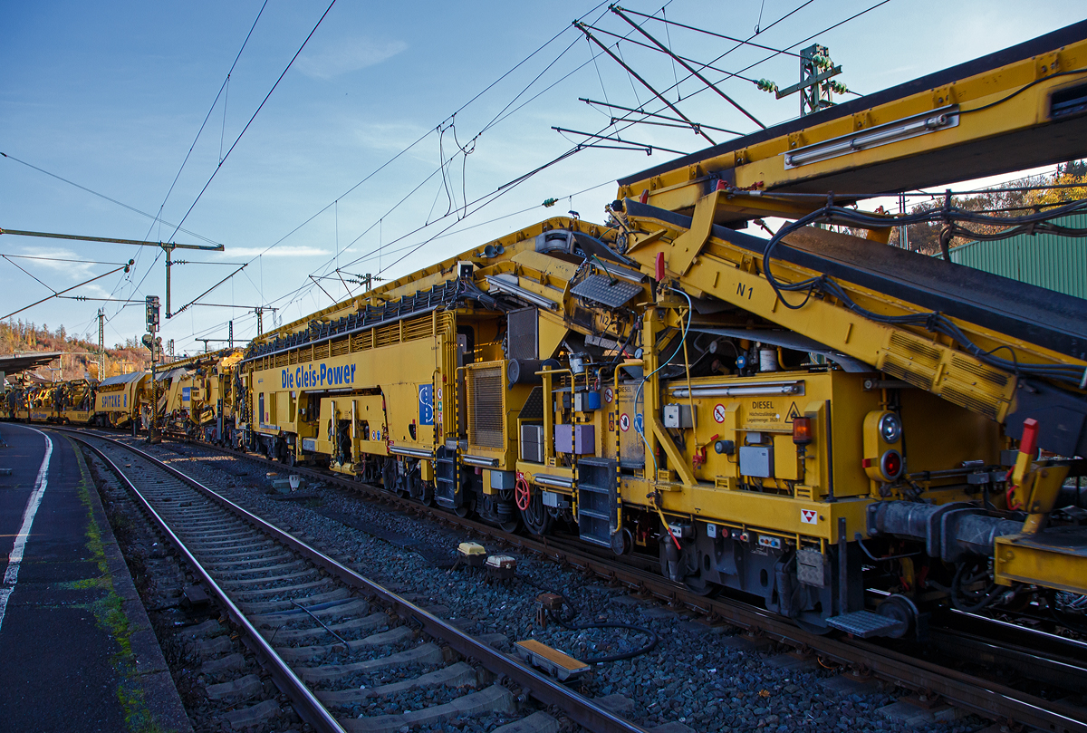 Die Plasser & Theurer Planumssanierungs- und Reinigungsmaschine RPM-RS-900 „Katharina die Große“ der SPITZKE SE (Großbeeren), Schweres Nebenfahrzeug Nr. D-SPAG 99 80 9415 004 – 1 (ex 97 19 35 501 18-1), am 09.11.2021 bei einer Zugdurchfahrt in Betzdorf (Sieg) in Richtung Siegen.

Hier als Detailbild die Stopf-u.  Einschotterungsmaschine SEM, (P&T Fabriknummer 4799), mit:
• Flexibler Einschotterung mittels Schwenkförderband mit Höhensteuerung.
• Integrierte, mittels Satellit kontinuierlich arbeitende Stopfmaschine mit 16 Stopfwerkzeugen und mit Vorkopfverdichtung.
• Nachlaufende integrierte Kehrwelle (am Übergabewagen)