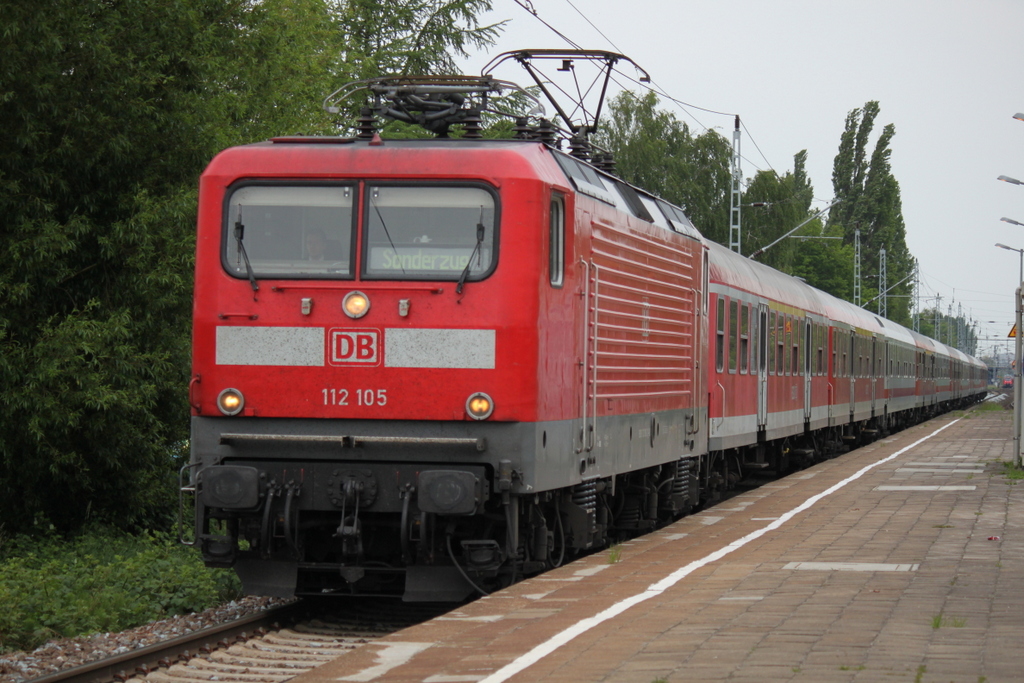 Die Rostocker 112 105-2 mit Sonderzug 13290 von Warnemnde nach Berlin-Zoo bei der Durchfahrt am 28.05.2015 im Haltepunkt Rostock-Holbeinplatz