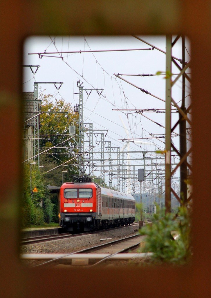 Durch den Mast geschaut...DB 112 147-4 mit dem SHE nach Neumünster bei der Durchfahrt in Jübek. 06.10.2013