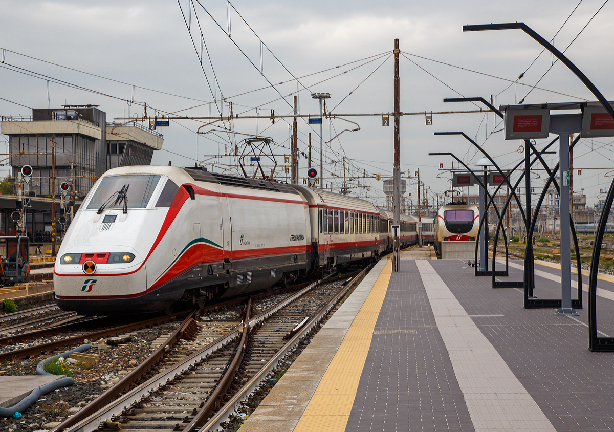 
Ein Frecciabianca (deutsch: weißer Pfeil) der Trenitalia fährt am 14.09.2017  in den Bahnhof Milano Centrale (Mailand Zentral) ein. 

Der Frecciabianca ist eine Zuggattung für Züge mit einer Höchstgeschwindigkeit von 200 km/h (IC), die nur im italienischen Gleichspannungsnetz verkehren. Oft werden sie als Triebzüge (ETR 500) bezeichnet...sind sie aber nicht, die Frecciabianca sind Lokbespannte Züge. Der Frecciabianca wird meist im Sandwich gefahren, das heißt eine E.414 vorne und eine weitere am anderen Ende, dazwischen vielen IC-Großraumwagen. Durch die IC-Wagen ist auch die Höchstgeschwindigkeit auf maximal 200 km/h beschränkt, die Loks könnten technisch 250 km/h fahren.

Die Loks wie hier die E.414 127-7 sind zwar ehemalige Triebköpfe der ersten Serie der ETR 500 (Monotensione = Ein-Spannung 3000 V DV) vom Typ 404 A, wurden aber ab 2007 zu E-Loks umgebaut. 