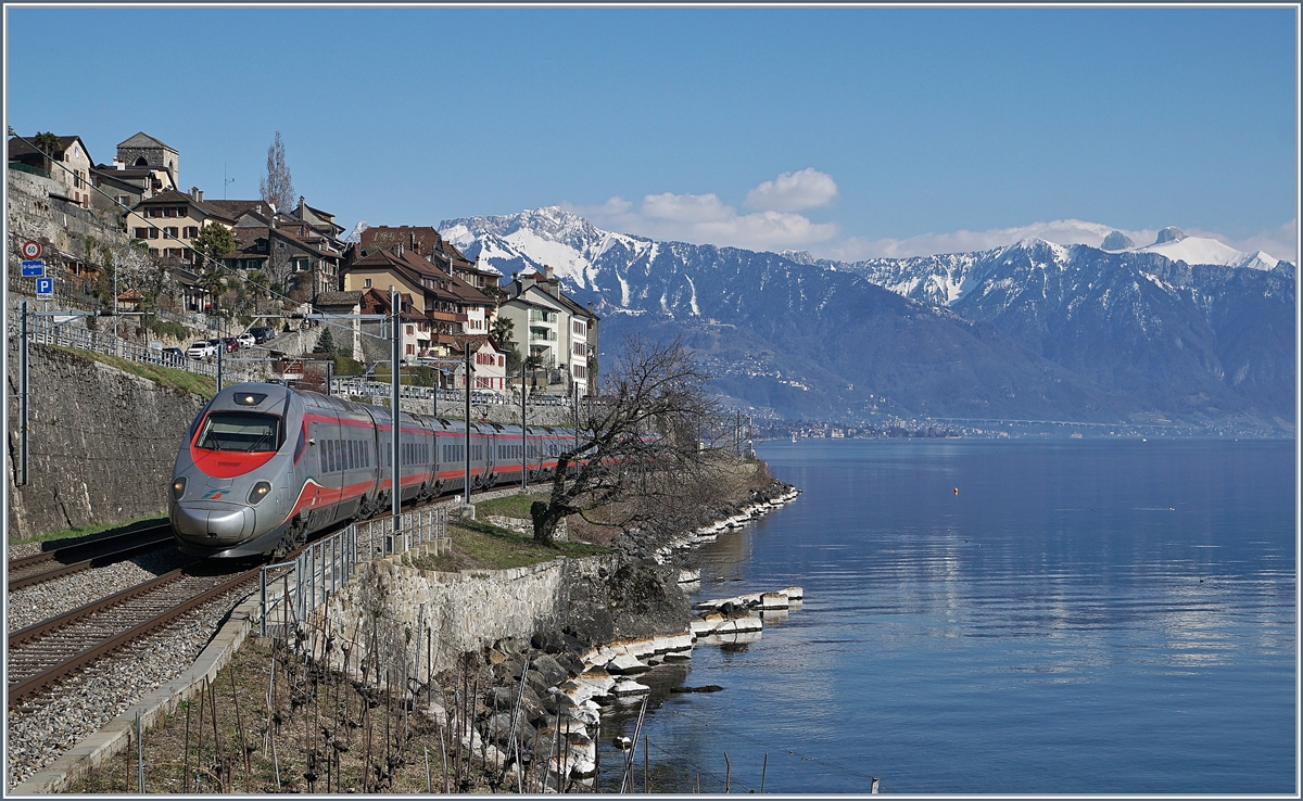 Ein FS Trenitalia ETR 610, als EC 34 von Milano nach Genève unterwegs zeigt sich bei St-Saphorin vor dem Hintergrund des malerischen Ortes und der noch von Schnee bedecken Berge.
24. März 2018