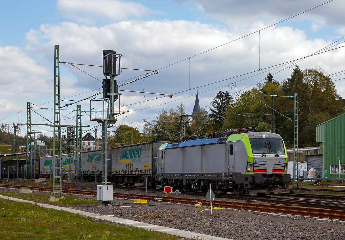 Eine der 25 neuen von der BLS Cargo in der 2. Serie bestellten Re 475 (Siemens Vectron MS)....
Die recht neue BLS Cargo 421 – Re 475 421-4 (91 85 4475 421-4 CH-BLSC) f�hrt am 07.05.2021 mit einem KLV-Zug durch den Bahnhof Betzdorf (Sieg) in Richtung K�ln.

Die Siemens Vectron MS wurden 2020 von Siemens Mobilitiy in M�nchen-Allach unter der Fabriknummer 22867 gebaut, sie hat die Zulassungen f�r CH/ D/ A/ I / NL/B und kann so vom Mittelmeer bis an die Nordsee ohne Lokwechsel durchfahren. Die BLS Re 475 der zweiten Serie 475 416 – 475 440 (es sind noch nicht alle ausgeliefert) haben zus�tzlich die Zulassung f�r Belgien (B). Sie haben eine H�chstgeschwindigkeit von 200 km/h und eine Leistung von 6.400 kW.

Nach Abschluss der Lieferungen der 2. Serie hat die BLS Cargo dann insgesamt 40 Loks der Baureihe Re 475 (Siemens Vectron MS). Der kleine Unterschied zwischen der beiden Serien ist nur das die Lok der 2. Serie auch durch Belgien 