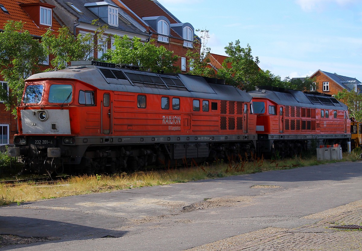 Fein ordentlich abgestellt stehen die DB 232 201-4(REV/BCS X/25.09.07, Verl/LMR/31.08.15) und 233 511-5(REV/BCS X/24.02.10) im dänischen Esbjerg und warten auf ihre Aufgaben. Die Aufnahme wurde von einem Parkplatz aus gemacht. Esbjerg 24.07.2015