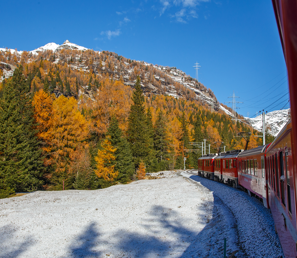 Geführt von den beiden RhB ABe 4/4 III Triebwagen Nr. 53  Tirano  und Nr. 54  Hakone  fährt unser RhB Regionalzug von Tirano nach St. Moritz, am 04.11.2019 von Cavaglia weiter nach Alp Grüm hinauf. Oben das Hotel Restaurant Belvedere Alp Grüm, links etwas tiefer die RhB Bahnstation Alp Grüm. Auch die Strecke der Berninabahn kann man hier und da erkennen.