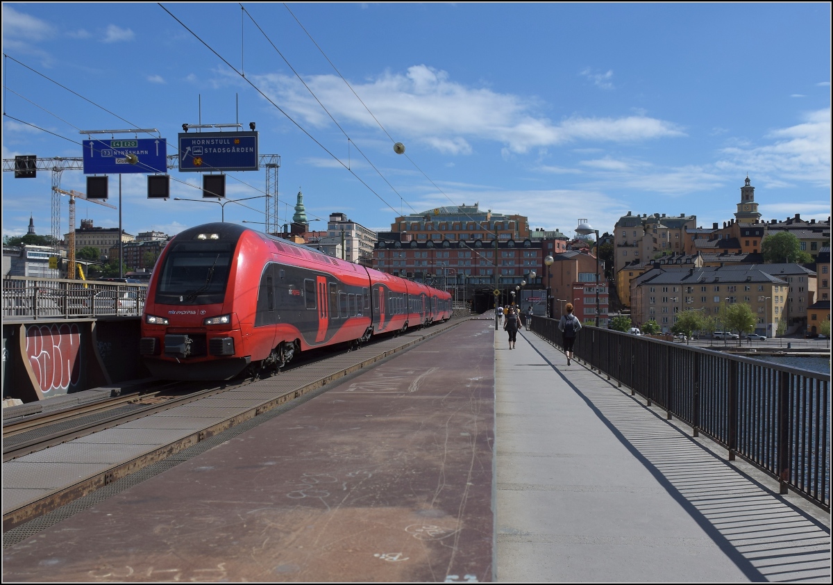 Hochgeschwindigkeits-Flirt in Schweden. 

X74 004 der MTR auf der südlichen Eisenbahnbrücke, der södra Järnvägsbron. Stockholm, Juni 2018.