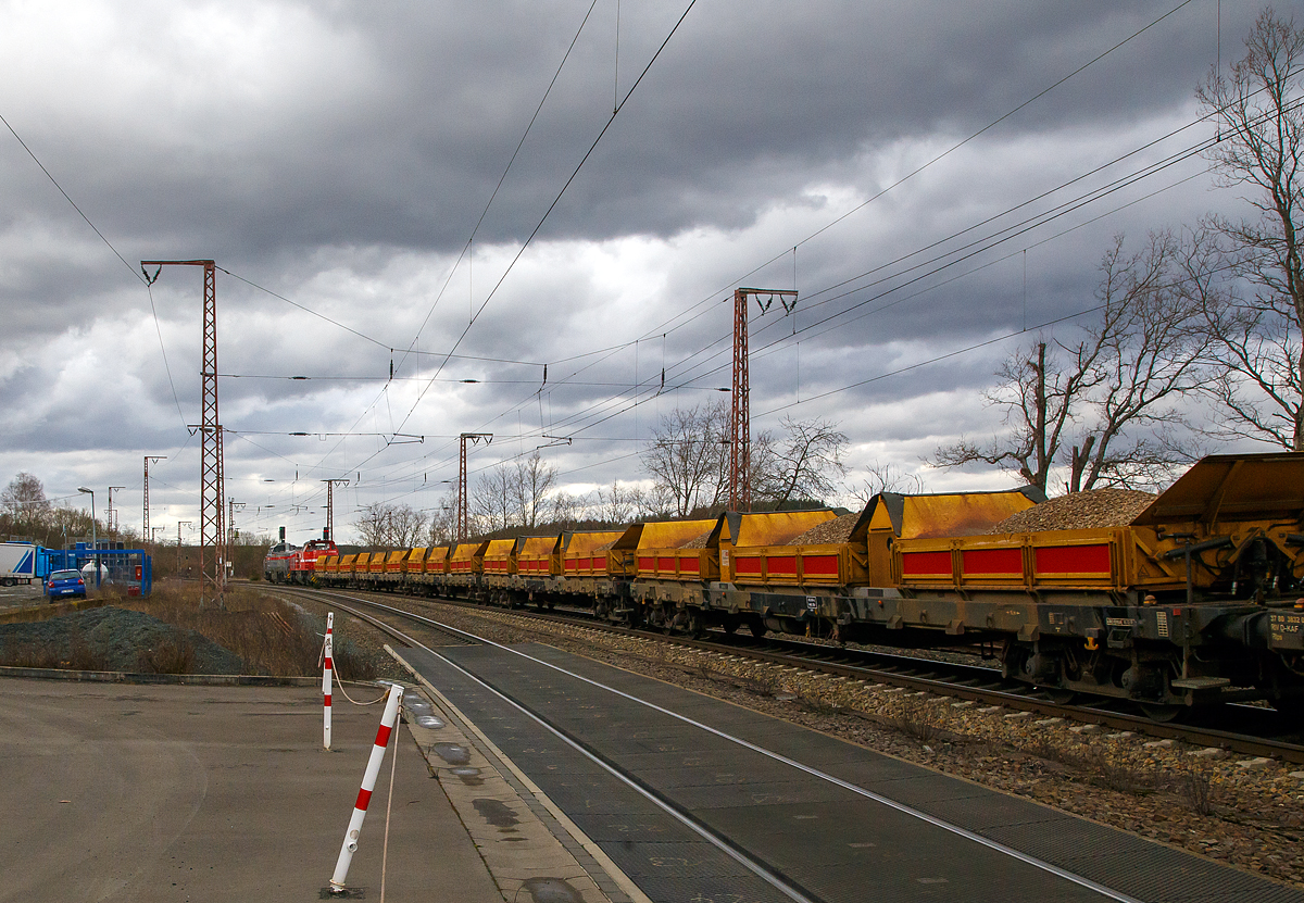 Im Doppelpack, ob man von einer Doppeltraktion sprechen ist mit nicht ganz klar, glaube aber nicht...
Die Vossloh G 12 – 4120 001-7 „Karl August“ (92 80 4120 001-7 D-KAF) und die Vossloh G 1000 BB - 271 022-6 „Charlotte“  (92 80 1271 022-6 D-KAF), ex HGK DH 49, beide von der KAF Falkenhahn Bau AG (Kreuztal) fahren am 11.03.2021, mit einem sehr langen Güterzug durch Rudersdorf (Kreis Siegen) in nördlicher Richtung, vermutlich Richtung Heimat Bf Kreuztal. Im Zugverband waren vorne einige mit Kies beladene KAF Kippwagen MK 45 DH „LW-Kipper“ der Gattung Rlps, dann etliche leere 2-achsiger Flachwagen für Schotter und Sand der Gattung NS Klmos 702 von Railpro und am Zugende noch vier 2-achsige Schüttgutwagen für Schotter der Gattung NS Fccpps von Railpro.

Von der Vossloh G 12 – 4120 001-7 „Karl August“ sind hier schon Daten und der Lebenslauf vorhanden, daher nur den Lebenslauf der Vossloh G 1000 BB - 271 022-6 „Charlotte“:
Die G 1000 BB wurde 2005 von Vossloh in Kiel unter der Fabriknummer 5001568 gebaut. Im Jahr 2006 wurde sie an die MRCE - Mitsui Rail Capital Europe B.V. verkauft, die die Lok an die HGK - Häfen und Güterverkehr Köln AG in Köln (HGK DH 49) vermietete, wo sie bis unter der NVR-Nummer 92 80 1271 022-6 D-DISPO fuhr. Danach hatte sie bis zum Verkauf im Jahr 2017 an die northrail GmbH in Hamburg, mehrere Mietstation. Von 2017 fuhr sie unter der NVR-Nummer 92 80 1271 022-6 D-NRAIL bis sie 2020 an die Michael Bugdoll Bau- und Sicherungsarbeiten e. K. in Dorsten ging und als 92 80 1271 022-6 D-MBBAU fuhr. 

Zum 01.01.2021 wurde sie an die KAF Falkenhahn Bau AG in Kreuztal verkauft und hört nun auf den Namen „Charlotte“ (92 80 1271 022-6 D-KAF).