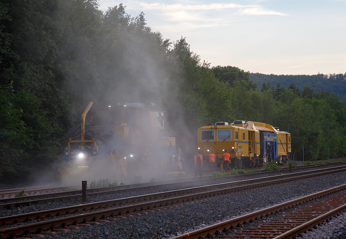 Im Einsatz am Gleis 4 im Bahnhof Herdorf am Abend des 11.06.2021, die Plasser & Theurer Schotterverteil- und Planiermaschine SSP 110 SW, Schweres Nebenfahrzeug Nr. D-DGU 99 80 9425 068-0, ex 97 16 46 516 18-9 D-DGU (ex Hering Gleisbau, ex Volker-Rail) und davor die Plasser & Theurer Universalstopfmaschine UNIMAT 09-475/4S (Kombinierte Gleis- und Weichenstopfmaschine), Schweres Nebenfahrzeug Nr. D-DGU 99 80 9424 001-2. Beide Maschinen gehören der der DGU - Deutsche Gleisbau Union aus Koblenz.