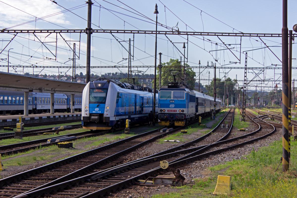 In der Abstellanlage des Bahnhofes Praha-Smchov warten zwei Rchlik-Zge, die auf unterschiedlichen Wegen in Richtung Brno fahren werden auf ihre Abfahrtszeit: Der moderne InterPanter 660 110 als R865 nimmt auf der Linie R19 den Weg ber Pardubice und Česk Třebov, whrend 362 167 mit R979 ab Koln den etwas direkteren Weg ber dr nad Szavou zum Bahnhof Krlovo Pole am Stadtrand von Brno nimmt.