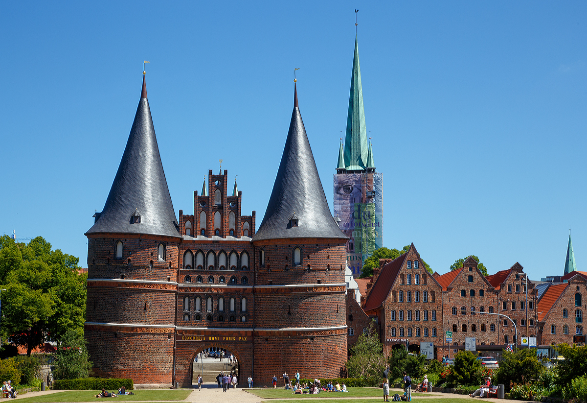 
Lübeck am 11.06.2015, blick auf das Holstentor von Westen (Feldseite) in Richtung der Altstadt. Rechts der (z.Z. verhüllte) Turm der Petrikirche, davor die historischen Salzspeicher. 

So schön gerade, wie wir von dem Stich, des Holstentors der sich auf der Rückseite 50-DM-Scheine befand ist es nicht- Daher ist mir hier auch das Ausrichten sehr schwer gefallen.