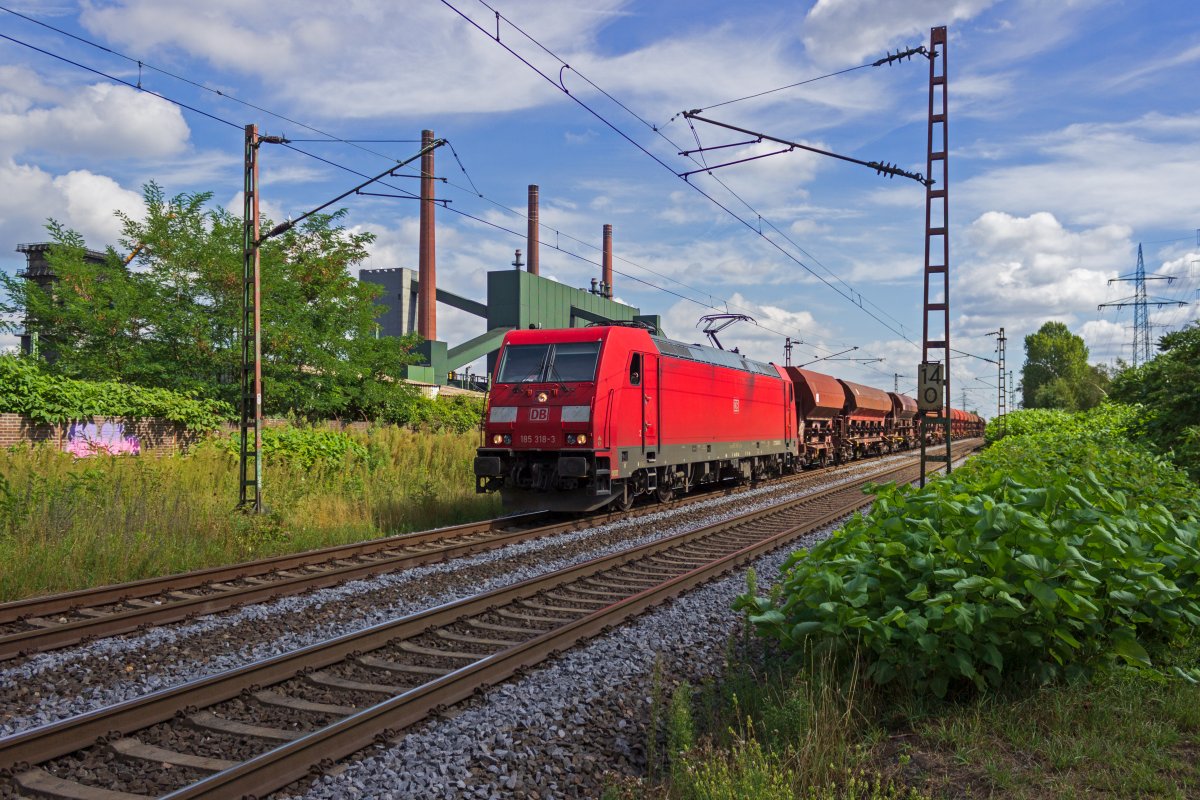Mit einem Ganzzug aus Selbstentladewagen rollt 185 318 am 18.08.2020 dem G�terbahnhof Bottrop-S�d entgegen.