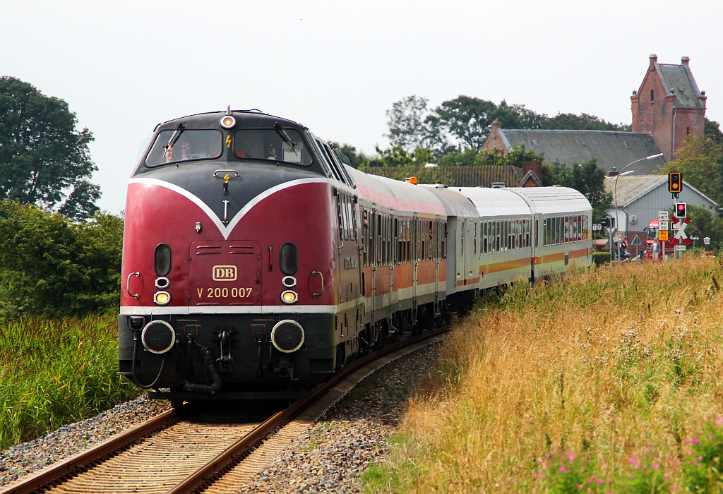 Mit gut 15min plus dieselt die V 200 007 hier mit dem Zug E12 von Dagebüll-Mole nach Niebüll über den Vordeich bei Dagebüll-Kirche(Miniserie Ende). 04.08.12