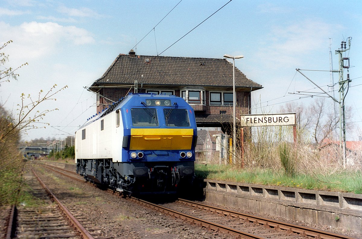 Nachdem die FLEX AG nach nur wenigen Monaten den Betrieb wieder eingestellt hatte übernahm Veolia/NOB den dann bezeichneten  Flensburg-Express  zwischen Flensburg und Hamburg. Gleichzeitig bereitete man sich darauf vor die Marschbahn in Betrieb zu nehmen. Zu diesem Zweck wurden die inzwischen in Kiel modifizierten Loks der Baureihe MaK DE 2700/Di6/ME 26 im neuen Farbkleid zum testen mehrfach ab Flensburg eingesetzt. Hier ein paar Bilder aus dem Archiv des Herrn Schikorr der diese Bilder zur Verfügung gestellt hat. Veolia/NOB MaK DE 2700-01 dieselt hier am alten Stellwerk in Flensburg vorbei. 26.04.2005